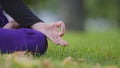 Close up female fingers folded in Jnana Mudra yoga position Padmasana. Unrecognizable buddhist woman meditating sits on