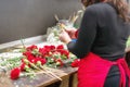 Close up of female florist creating beautiful red carnation bouquet at flower shop. Royalty Free Stock Photo