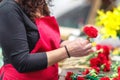 Close up of female florist creating beautiful red carnation bouquet at flower shop. Royalty Free Stock Photo