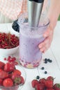 Close up of a female hand blending fruits and berries Royalty Free Stock Photo