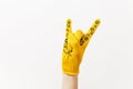 Close up of female hand in building yellow gloves horns gesture, depicting heavy metal rock and roll sign isolated on Royalty Free Stock Photo