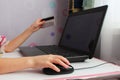 Close up of female hand on computer mouse and holding a credit card. Royalty Free Stock Photo