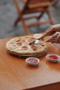 close up female hand cutting pizza with knife and fork Royalty Free Stock Photo