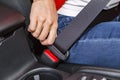 Close up female hand fasten seat belt in car