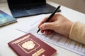Close up of female hand filing out a visa application with a Russian passport Royalty Free Stock Photo