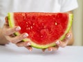 Close up Female Hand with French Manicure on Nails Holding a Slice of Fresh Watermelon. Clean eating and summer concept Royalty Free Stock Photo