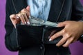 close-up of a female hand holding a black wallet in which there are dollars. Royalty Free Stock Photo