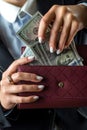 close-up of a female hand holding a black wallet in which there are dollars. Royalty Free Stock Photo