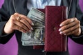 close-up of a female hand holding a black wallet in which there are dollars. Royalty Free Stock Photo