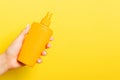 Close up of female hand holding a spray of cosmetics product at yellow background with copy space Royalty Free Stock Photo