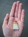 Close-up of a female hand holding a variety of colorful pills in her palm looks like a Christmas tree. Royalty Free Stock Photo