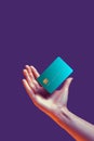 Close up female hand holds levitating template mockup Bank credit card with online service isolated on violet background