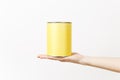 Close up female hand horizontal holds yellow empty paint tin can with copy space isolated on white background Royalty Free Stock Photo