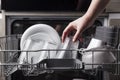Open dishwasher with clean cutlery, glasses, dishes inside in the home kitchen Royalty Free Stock Photo