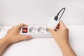 Close-up of hand plugging a plug into a multiple socket Royalty Free Stock Photo