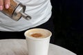 Close-up of a female hand pouring brown sugar from a dispenser into a white plastic cup with tea or coffee Royalty Free Stock Photo