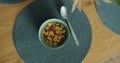 Close-up of female hand pouring milk on colorful cereal corn flakes in a bowl. Healthy nutrition and people concept. Royalty Free Stock Photo