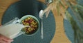 Close-up of female hand pouring milk on colorful cereal corn flakes in a bowl. Healthy nutrition and people concept. Royalty Free Stock Photo