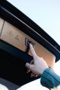 Close-up of female hand pressing the trunk opening and closing button of her car.