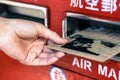 Close up of female hand putting envelope into mailbox