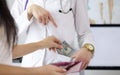 Female hand putting money to doctor pocket Royalty Free Stock Photo