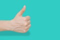 Close up of female hand showing thumbs up gesture over blue pastel background with clipping path. Body language that says ok, all Royalty Free Stock Photo