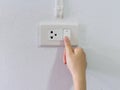 Close up female hand turning on or off on grey light switch with Royalty Free Stock Photo