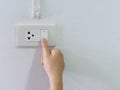 Close up female hand turning on or off on grey light switch with Royalty Free Stock Photo