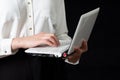 Close-up of a female hand using a laptop computer and touching the screen, isolated on black background Royalty Free Stock Photo