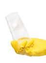 Close up of female hand in yellow protective rubber glove holding clean transparent drinking glass in foam Royalty Free Stock Photo