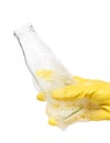 Close up of female hand in yellow protective rubber glove holding empty clean transparent glass milk bottle in foam Royalty Free Stock Photo