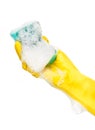 Close up of female hand in yellow protective rubber glove holding green cleaning sponge in foam Royalty Free Stock Photo