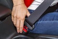 Close up female hand fasten seat belt in car