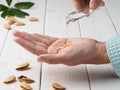 Close-up of female hands while applying moisturizing lotion or natural almond essential oil in order to repair damaged and dry