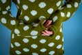 Close up of a female hands with black nails in a green sweater with white polka dots