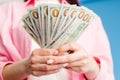 Close-up of female hands counting stack of hundred dollar bills blue background Royalty Free Stock Photo