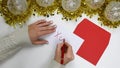 Close up on female hands writing a Christmas letter with text `xoxo`