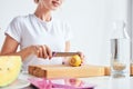 Female hands cutting fruits on a board