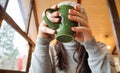 Close up of female hands with a drink mug. A girl in a gray sweater holds a cup of coffee or cocoa in a cafe at the table and Royalty Free Stock Photo