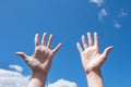 Close-up of female hands, empty open palms on a background of blue sky. Number ten in sign language. Copy space Royalty Free Stock Photo