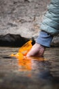 Close-up of female hands filling fresh cold water of a mountain stream into a reusable travel bottle during a water