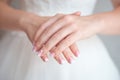 Close-up female hands in focus with blurred slim waist body on background.