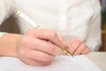 Close up of female hands holding a ballpoint pen and signing contract Royalty Free Stock Photo