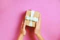 Close up of female hands holding birthday gift in vintage craft paper wrapping. Femenine composition with present in woman`s arms Royalty Free Stock Photo