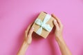 Close up of female hands holding birthday gift in vintage craft paper wrapping. Femenine composition with present in woman`s arms Royalty Free Stock Photo