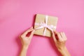 Close up of female hands holding birthday gift in vintage craft paper wrapping. Femenine composition with present in woman`s arms Royalty Free Stock Photo