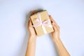 Close up of female hands holding birthday gift in vintage craft paper wrapping. Femenine composition with present in woman`s arms Royalty Free Stock Photo