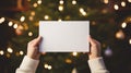 Close-up of female hands holding blank paper on christmas background Royalty Free Stock Photo