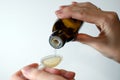 Close-up of female hands holding a bottle of expectorant cough syrup and pouring it with a measuring spoon.