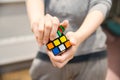 Close up of female hands holding a colourful rubik`s cube